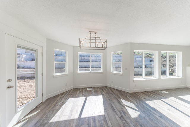 64 N Bywater Way, Brigham City, UT 84302 - unfurnished dining area featuring wood finished floors, a chandelier, and baseboards