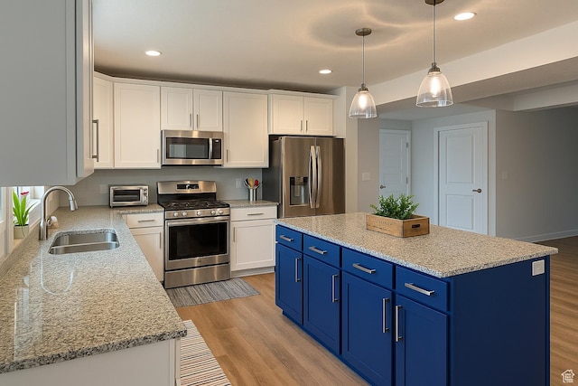 2685 E White Birch Dr, Eagle Mountain, UT 84005 - kitchen featuring appliances with stainless steel finishes, a sink, blue cabinets, white cabinetry, and light wood finished floors