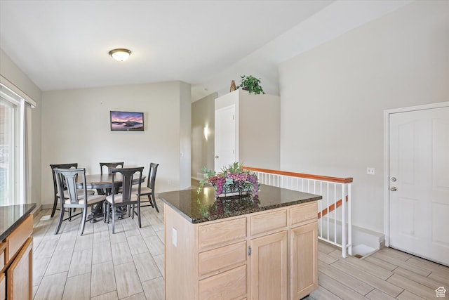 3018 S Asplund Cir, Salt Lake City, UT 84119 - kitchen with lofted ceiling, light brown cabinetry, dark stone counters, a kitchen island, and wood tiled floor