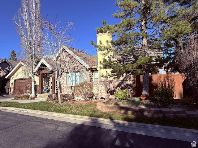 6991 S Canyon Pines Cir E, Cottonwood Heights, UT 84121 - view of front of home with stone siding, fence, a chimney, a garage, and concrete driveway