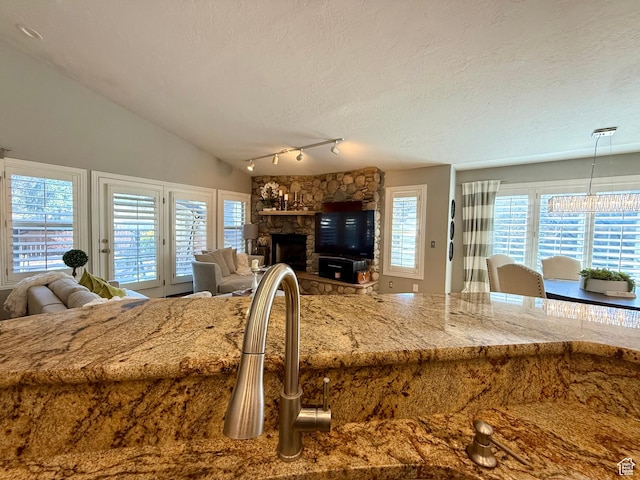 6991 S Canyon Pines Cir E, Cottonwood Heights, UT 84121 - interior space featuring a stone fireplace, access to exterior, vaulted ceiling, and a textured ceiling