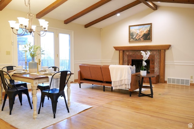 3885 E Viewcrest Dr, Millcreek, UT 84124 - dining area featuring a notable chandelier, light wood-type flooring, visible vents, a tile fireplace, and vaulted ceiling with beams