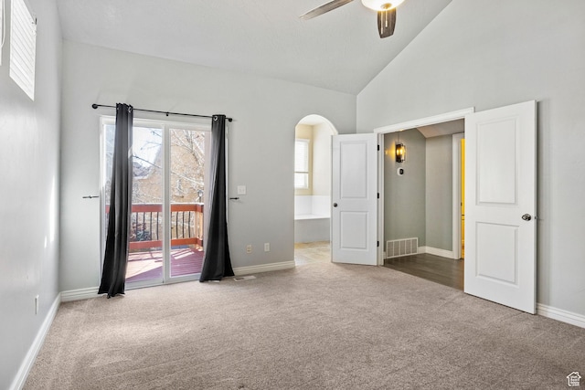 unfurnished bedroom with high vaulted ceiling, visible vents, carpet, access to outside, and arched walkways