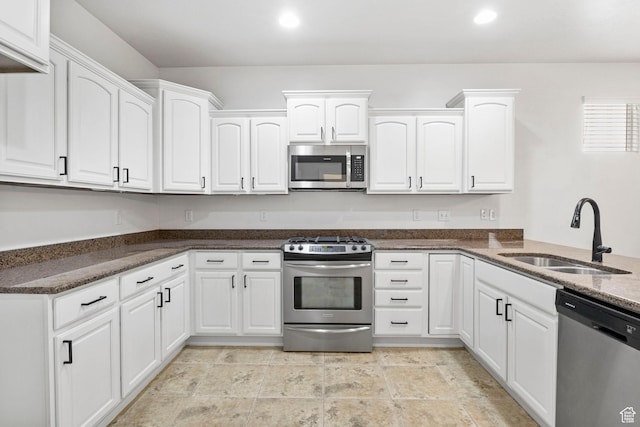 kitchen with a sink, appliances with stainless steel finishes, white cabinets, recessed lighting, and dark stone counters