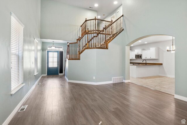 entrance foyer featuring a high ceiling, dark wood finished floors, and visible vents