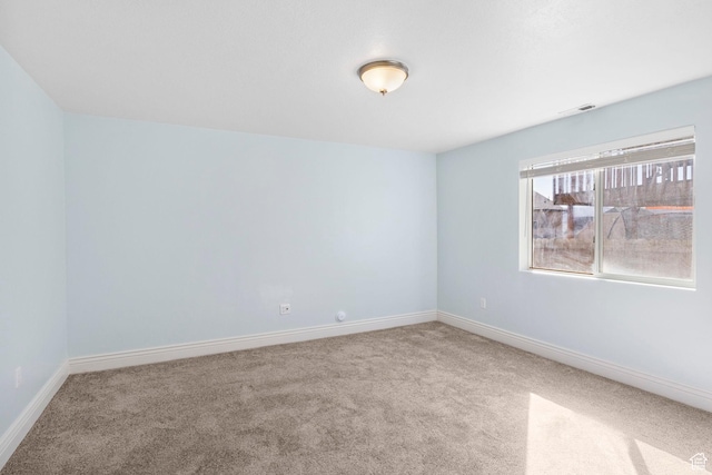 carpeted spare room with baseboards and visible vents