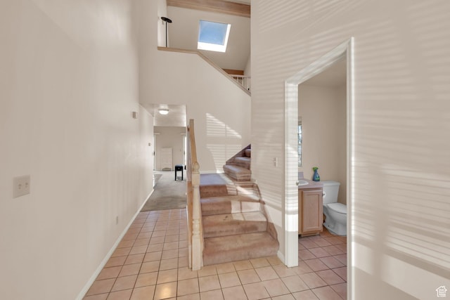 882 Schneitter Cir, Midway, UT 84049 - staircase featuring tile patterned flooring, a skylight, baseboards, and a towering ceiling