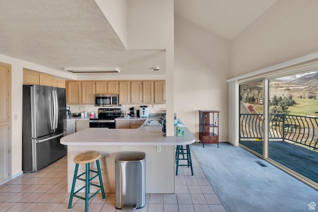 882 Schneitter Cir, Midway, UT 84049 - kitchen featuring appliances with stainless steel finishes, light brown cabinets, a sink, light tile patterned floors, and a peninsula
