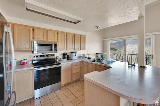 882 Schneitter Cir, Midway, UT 84049 - kitchen featuring appliances with stainless steel finishes, light brown cabinets, a peninsula, light tile patterned floors, and light countertops