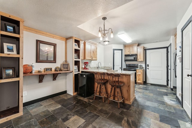 483 N 2650 W Unit 6, Tremonton, UT 84337 - kitchen with black appliances, stone finish flooring, a kitchen bar, and a peninsula