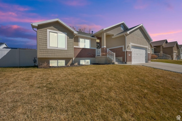 single story home featuring driveway, an attached garage, fence, and a lawn