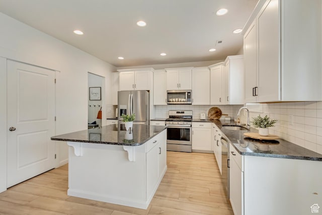 2022 E 970 N, Spanish Fork, UT 84660 - kitchen with stainless steel appliances, a sink, light wood-style flooring, white cabinets, and a kitchen island