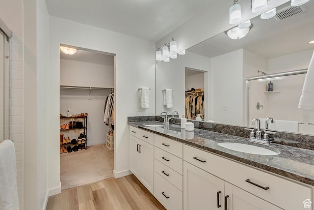 2022 E 970 N, Spanish Fork, UT 84660 - bathroom with a shower stall, wood finished floors, double vanity, a spacious closet, and baseboards