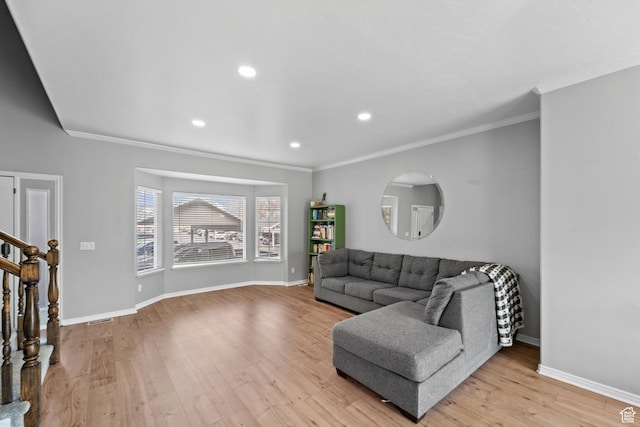 living room featuring baseboards, ornamental molding, and light wood-style floors