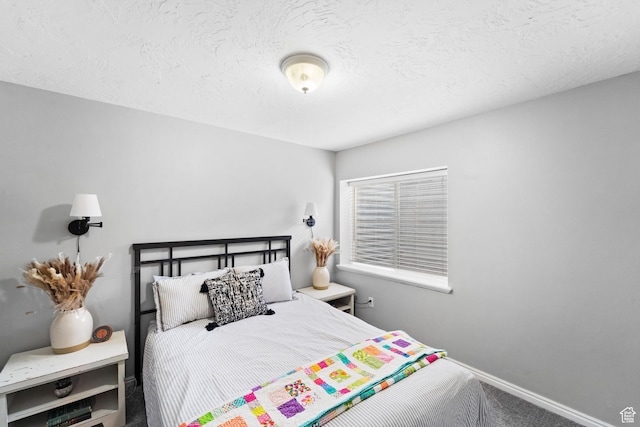 carpeted bedroom featuring baseboards and a textured ceiling