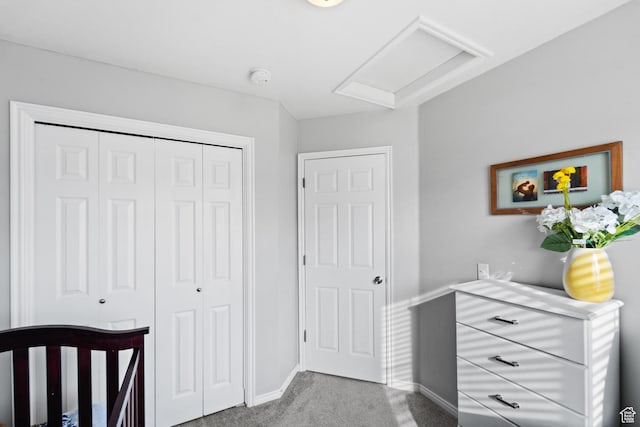 bedroom featuring a closet, carpet, attic access, and baseboards