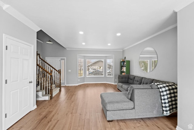 living area with crown molding, stairway, and light wood finished floors