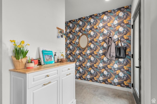 bar with baseboards and wallpapered walls