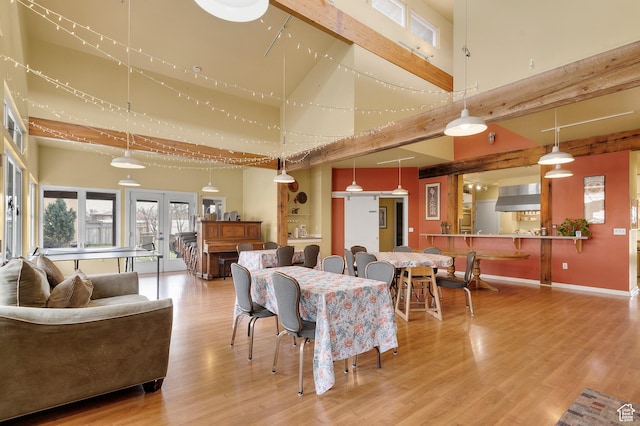 dining area with baseboards, a high ceiling, and wood finished floors