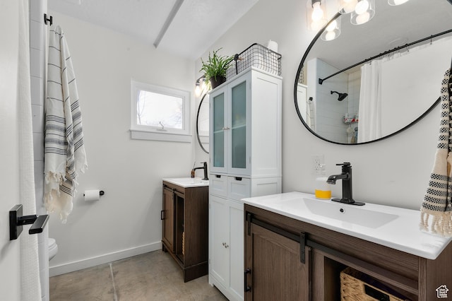 bathroom with a sink, two vanities, and baseboards