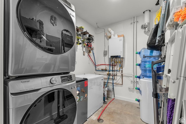 washroom featuring baseboards, stacked washer / drying machine, and laundry area