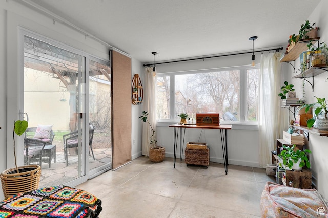 interior space with concrete flooring, baseboards, and plenty of natural light