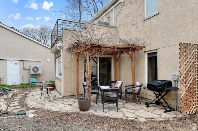 rear view of property featuring ac unit, stucco siding, and a patio