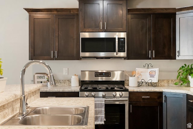 259 W 40 N, Hyrum, UT 84319 - kitchen with stainless steel appliances, a sink, dark brown cabinetry, and light countertops