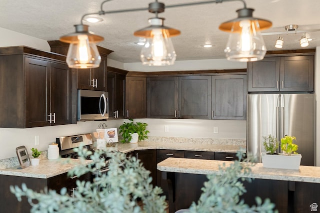 259 W 40 N, Hyrum, UT 84319 - kitchen with stainless steel appliances, dark brown cabinetry, and hanging light fixtures