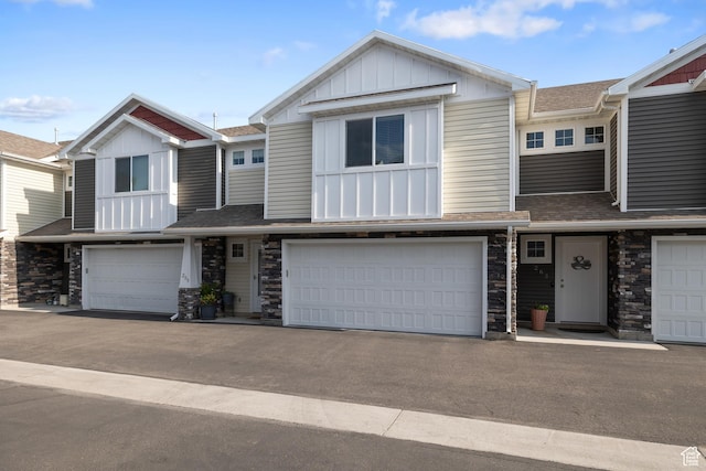 259 W 40 N, Hyrum, UT 84319 - view of property featuring board and batten siding, an attached garage, roof with shingles, and stone siding