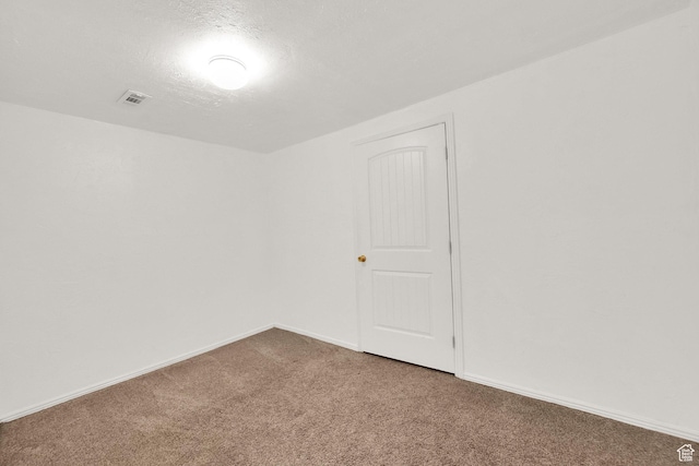 carpeted empty room featuring visible vents and baseboards