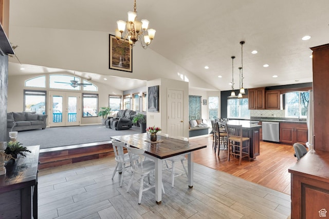dining room with light wood-type flooring, recessed lighting, high vaulted ceiling, and ceiling fan with notable chandelier