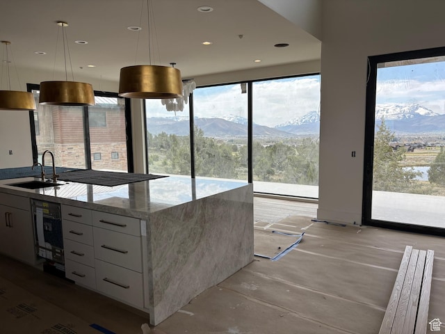 2220 E Flat Top Mountain Dr, Heber City, UT 84032 - kitchen with a sink, modern cabinets, white cabinets, light stone counters, and decorative light fixtures