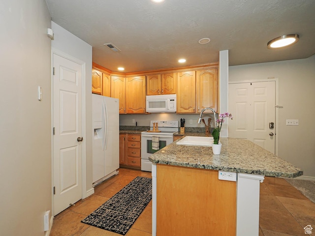 3745 S 700 E Unit 104, Millcreek, UT 84106 - kitchen with white appliances, light stone countertops, a sink, visible vents, and a peninsula