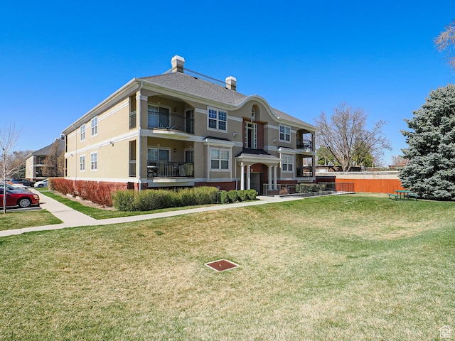 3745 S 700 E Unit 104, Millcreek, UT 84106 - view of front of home featuring a front lawn, a chimney, and stucco siding