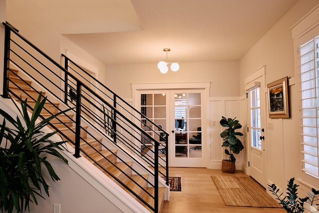 6889 W Lake Ave, South Jordan, UT 84009 - entryway with stairway, an inviting chandelier, a wainscoted wall, a decorative wall, and wood finished floors
