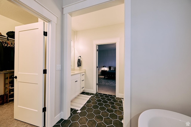 6889 W Lake Ave, South Jordan, UT 84009 - full bathroom featuring a freestanding bath, vanity, a walk in closet, and baseboards
