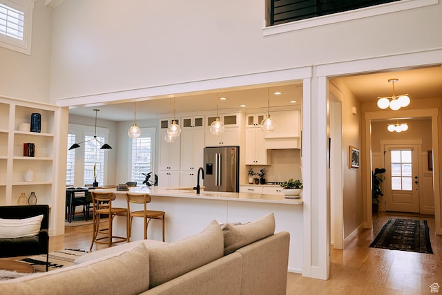 6889 W Lake Ave, South Jordan, UT 84009 - living room with a high ceiling, light wood-style flooring, and a healthy amount of sunlight