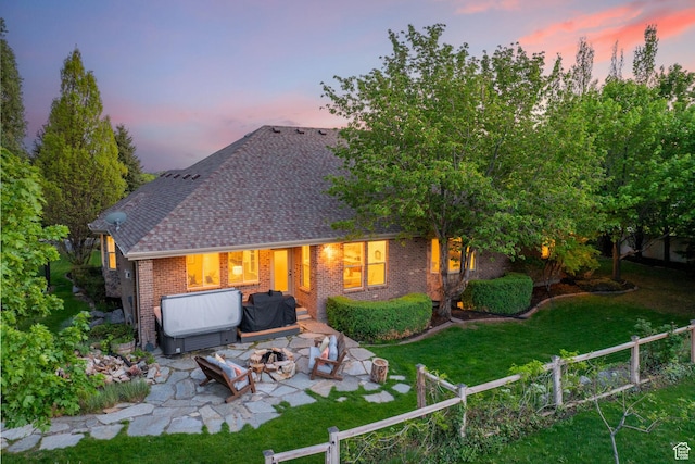 6208 W Bull River Rd, Highland, UT 84003 - back of property at dusk featuring brick siding, a patio area, a fire pit, and a shingled roof