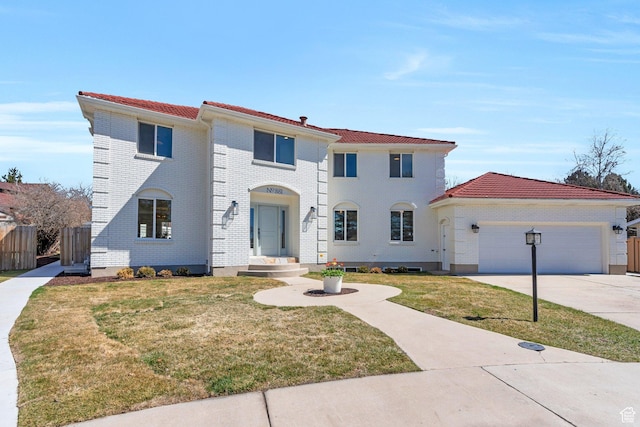 881 S 635 W, Orem, UT 84058 - mediterranean / spanish home featuring concrete driveway, a front lawn, fence, and an attached garage