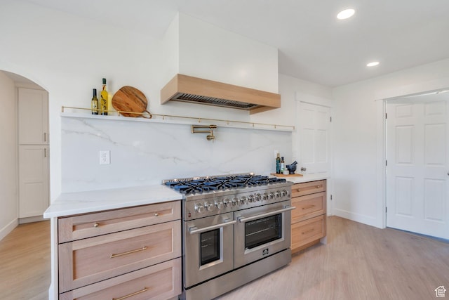 881 S 635 W, Orem, UT 84058 - kitchen featuring decorative backsplash, light wood-type flooring, premium range hood, and range with two ovens