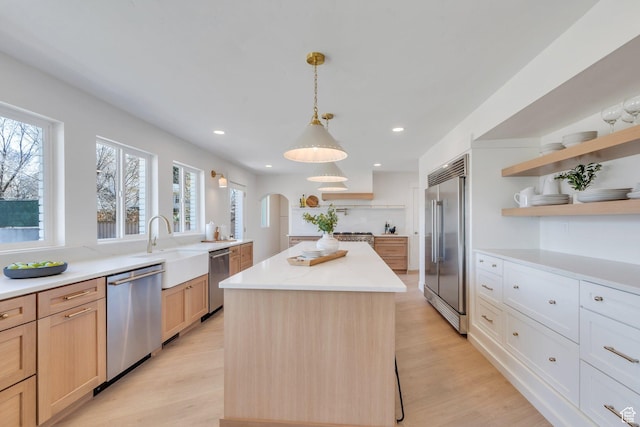 881 S 635 W, Orem, UT 84058 - kitchen with light countertops, open shelves, a center island, stainless steel appliances, and arched walkways