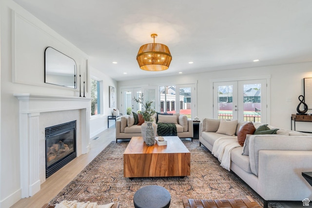 881 S 635 W, Orem, UT 84058 - living room with french doors, a healthy amount of sunlight, a glass covered fireplace, and light wood-style floors