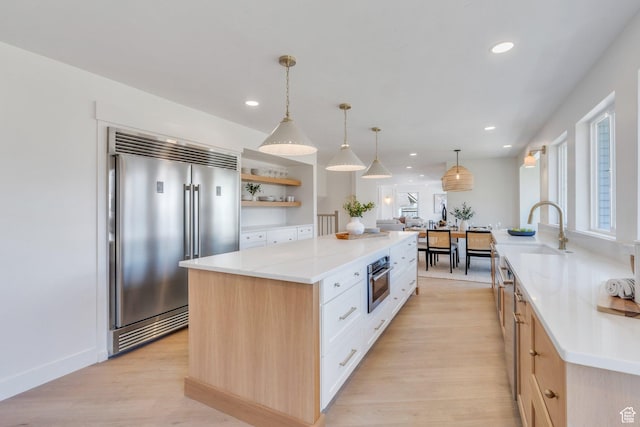 881 S 635 W, Orem, UT 84058 - kitchen with a kitchen island, appliances with stainless steel finishes, a sink, open shelves, and light wood-type flooring