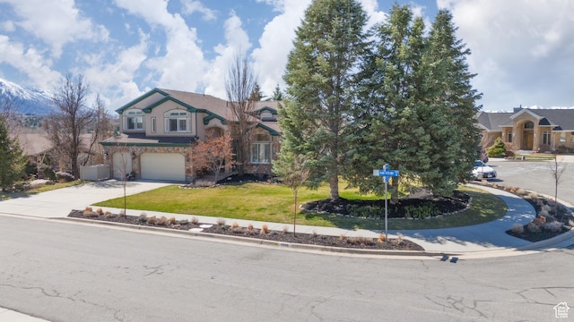 view of front of house featuring a front lawn, stone siding, a garage, and concrete driveway
