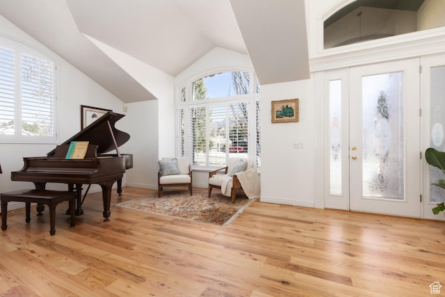 entrance foyer featuring light wood-style flooring, a healthy amount of sunlight, and lofted ceiling