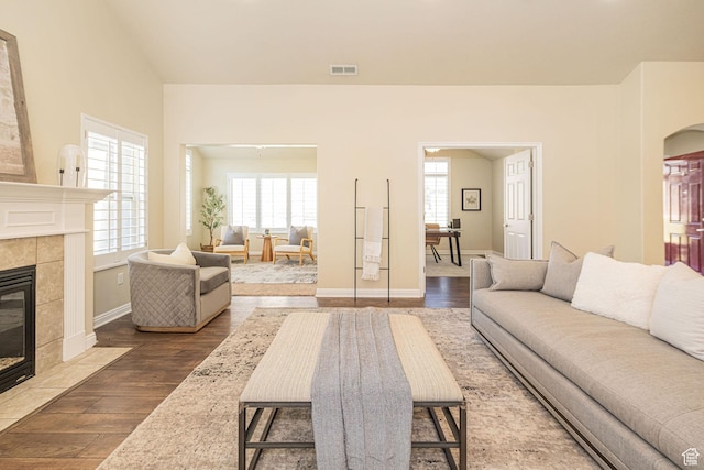1886 S 830 W Unit D, Syracuse, UT 84075 - living area featuring vaulted ceiling, a tile fireplace, wood finished floors, baseboards, and visible vents