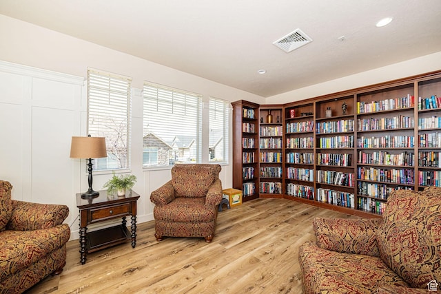 1886 S 830 W Unit D, Syracuse, UT 84075 - living area featuring wood finished floors, bookshelves, and visible vents