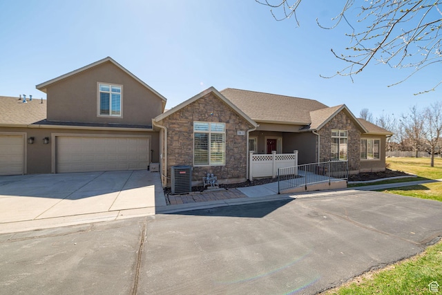 1886 S 830 W Unit D, Syracuse, UT 84075 - view of front of property featuring stone siding, driveway, fence, an attached garage, and stucco siding