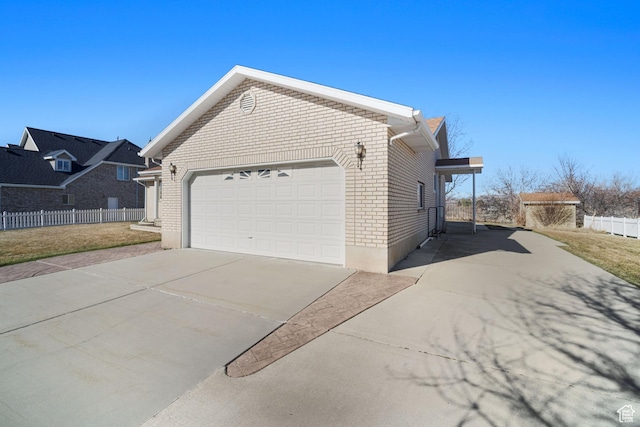 view of property exterior featuring brick siding, driveway, fence, and an attached garage